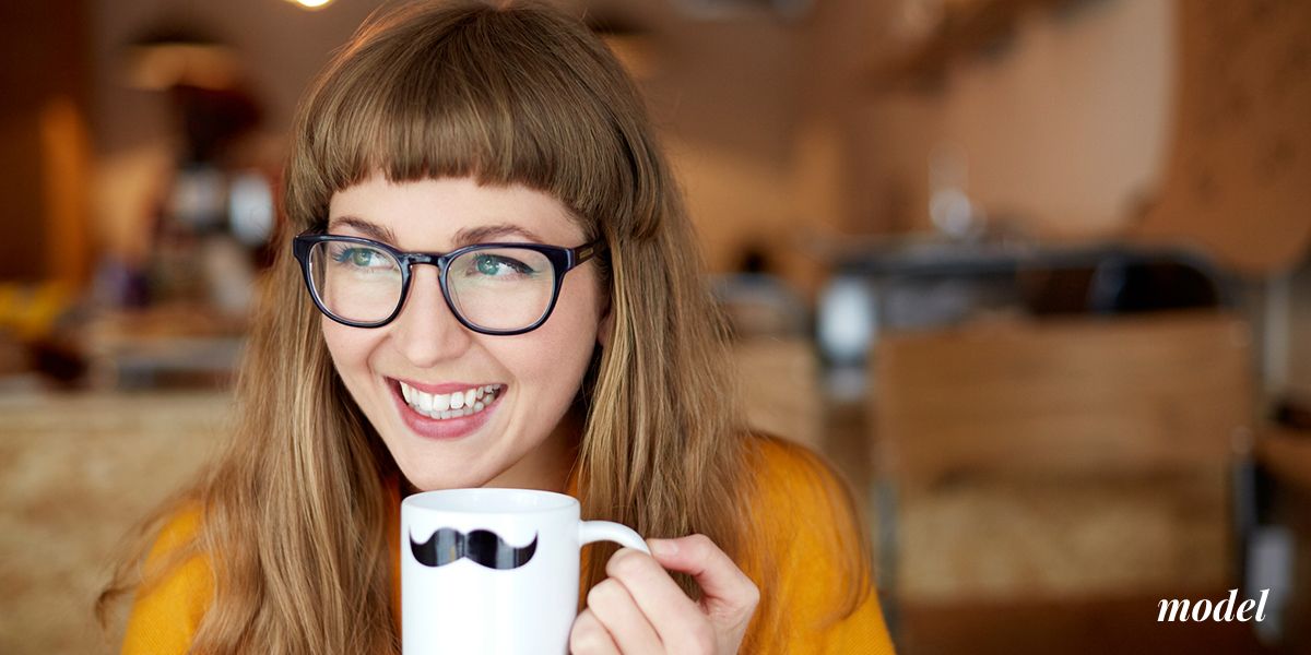 Smiling Model with Glasses Holding Mug With a Mustache